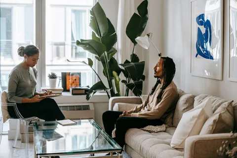 A calm one-on-one conversation in a plant-filled, naturally lit room