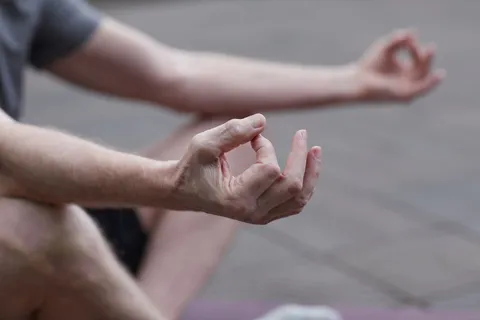 Close-up of hands resting in a relaxed meditation gesture